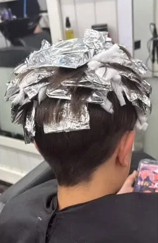 Antes: chico con las mechas puestas en papel de aluminio, de espaldas